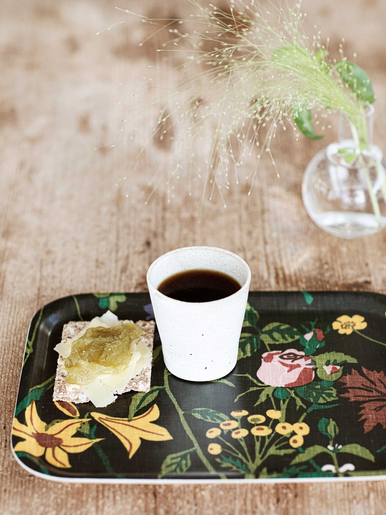 Ros och Lilja bricka svart med en kopp kaffe och smörgås på ett bord